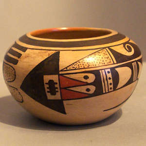 Red and black bird element and geometric design on a yellowware bowl
