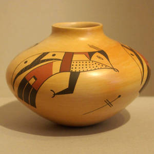 Red and black bird element designs on a yellow ware jar