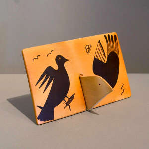 Bird and corn design with fire clouds on a black on yellow tile