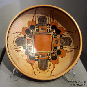 Bird element and moth motif inside this polychrome yellow ware bowl with a geometric design outside