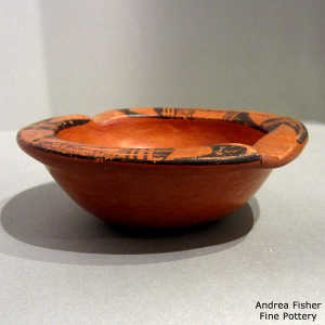 Black geometric design around the rim of a red ware ashtray