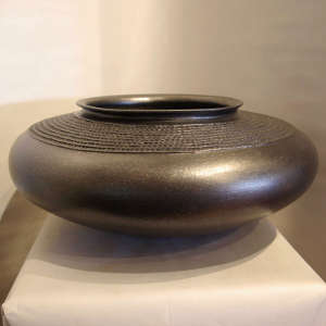 Corrugated shoulder on a micaceous black bowl