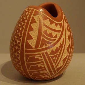 Sgraffito geometric designs on a polished red jar