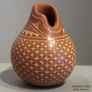 Snowflake and geometric design on a polished red jar with an organic opening