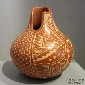 An organic opening and a sgraffito geometric design on a red jar