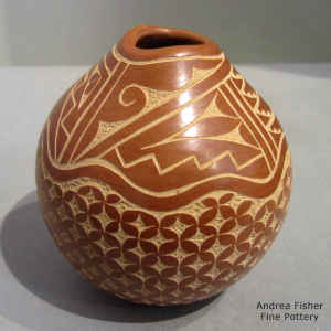 Sgraffito snowflake and geometric design on a red jar with an organic opening