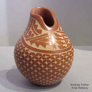 Sgraffito geometric design on a red jar with an organic opening