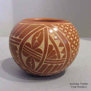 A sgraffito geometric design on a red jar