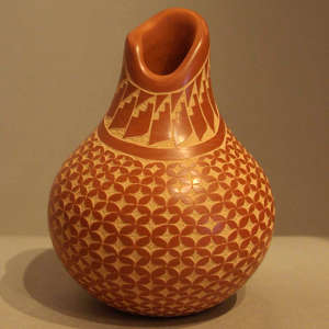 Sgraffito geometric design on a red jar with an organic opening