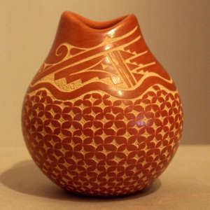 Sgraffito geometric design on a red jar with an organic opening