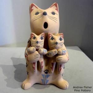 Two kittens on a feline storyteller figure