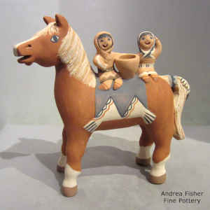 2 children riding on the back of a horse