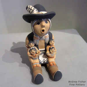 4 children on the lap of a grandfather storyteller wearing a cowboy hat