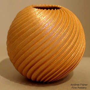 Spiral design deep cut into a golden micaceous seed pot