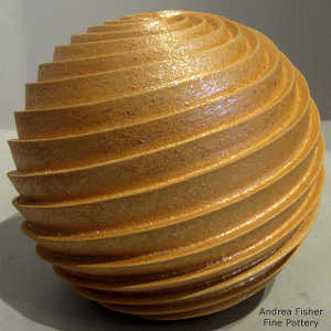 Deep carved spiral design on a golden micaceous seed pot