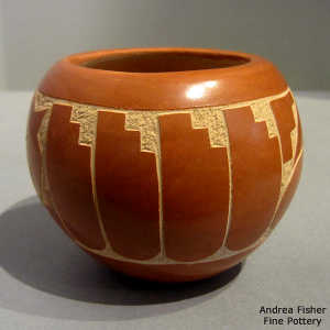 Sgraffito feather and geometric design on a polished red jar