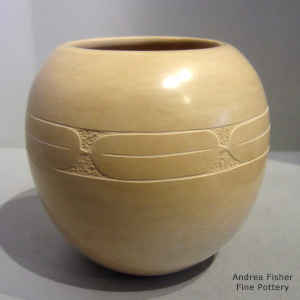 Sgraffito geometric design on a polished tan jar