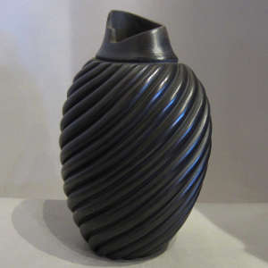 Oval kiva step opening on a black carved melon jar
