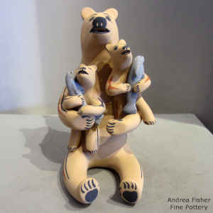 Two cubs holding fish on a bear storyteller figure