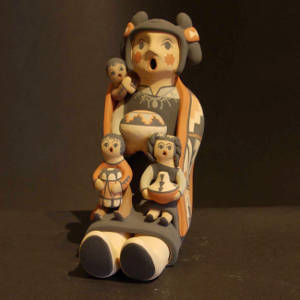 Three children, a blanket and a pot on a grandmother storyteller