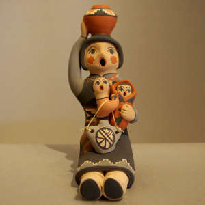 Two children on a grandmother storyteller with a pot on her head