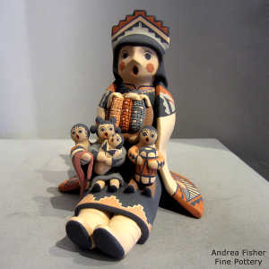 4 children on a grandmother storyteller with a manta and tablita