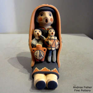 2 children on a grandmother storyteller wearing a manta