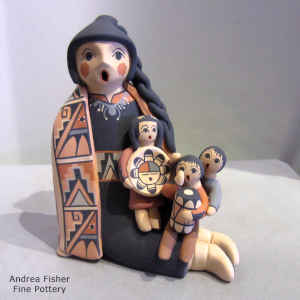 3 children on a grandmother storyteller wearing a manta