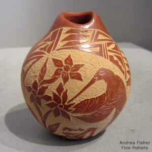 Sgraffito hummingbird and flower design on a red seed pot with an organic opening