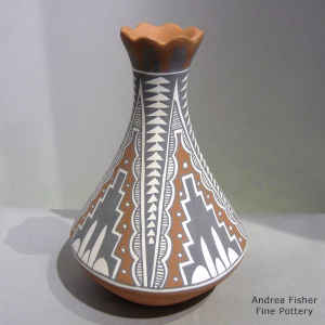 A 4-panel geometric design on a polychrome vase with a flared and scalloped rim