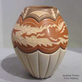 Lightly carved and sgraffito geometric and avanyu design on a polychforme jar with a carved melon base