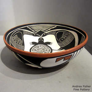 Geometric design outside and black and white turtle, bird and geometric design inside a polychorme bowl