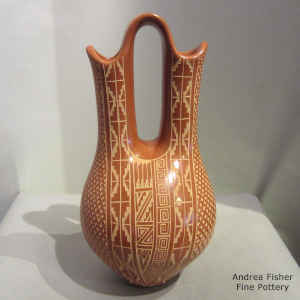 A sgraffito geometric design on a polished red wedding vase
