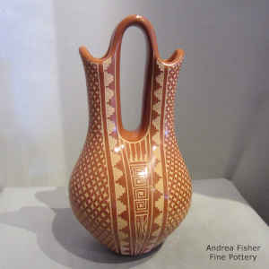 A sgraffito geometric design on a polished red wedding vase