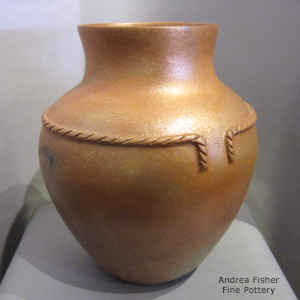 Fire clouds on a golden mcaceous jar with a raised rope band around the shoulder