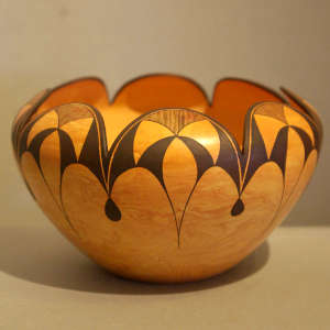 Black geometric design on a Mixed clay jar with a scalloped rim