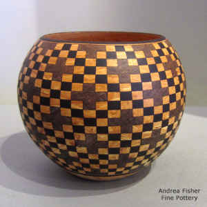 Checkerboard and cross geometric designs on a mixed clay jar