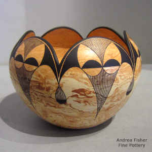 Black geometric design on a marbleized clay jar with a scalloped rim