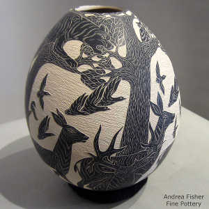Sgraffito nature and wildlife design on a black and white jar