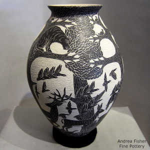 Sgraffito nature and wildlife design on a black and white jar