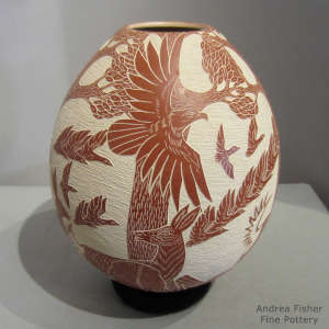 Sgraffito wildlife design on a red and white jar