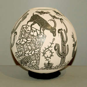 Sgraffito wildlife design on a black on tan jar