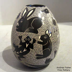 Sgrafftio animal and reptile design with a mesh background on a black and white jar