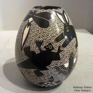Sgraffito reptile, insect and animal design on a black and white jar