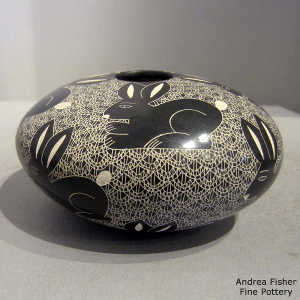 Sgraffito rabbit and mesh design on a black and white jar