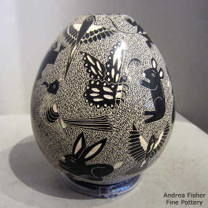 Sgraffito animal, bird, lizard, butterfly, dragonfly and mesh motif on a black and white jar