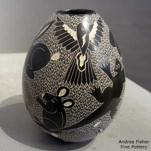 Sgraffito lizard, bird, dragonfly and animal design on a black and white jar