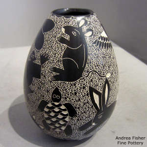 Sgraffito animal, insect and mesh design on a black and white jar