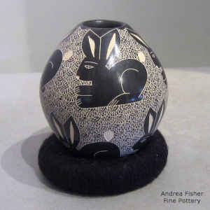 Sgraffito animal, bird and insect designs on a black and white jar