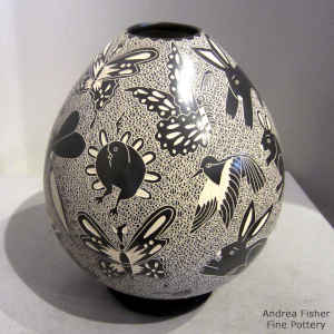 Sgraffito animal, bird, reptile and insect designs on a black and white jar
